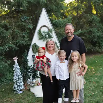 Steve Weber smiling outdoors with his wife and three children